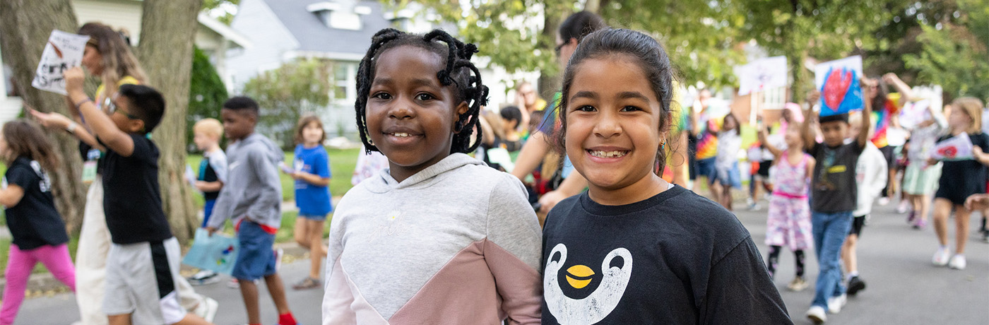 students holding hands and smiling